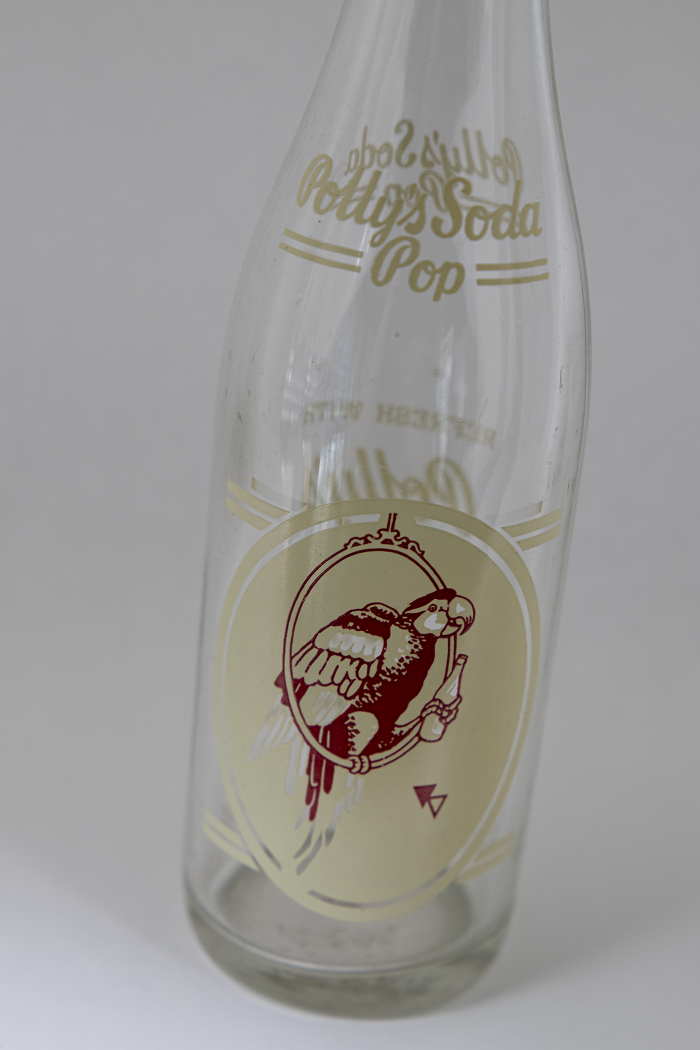 empty Polly's Pop Bottle with golden logo of a parrot